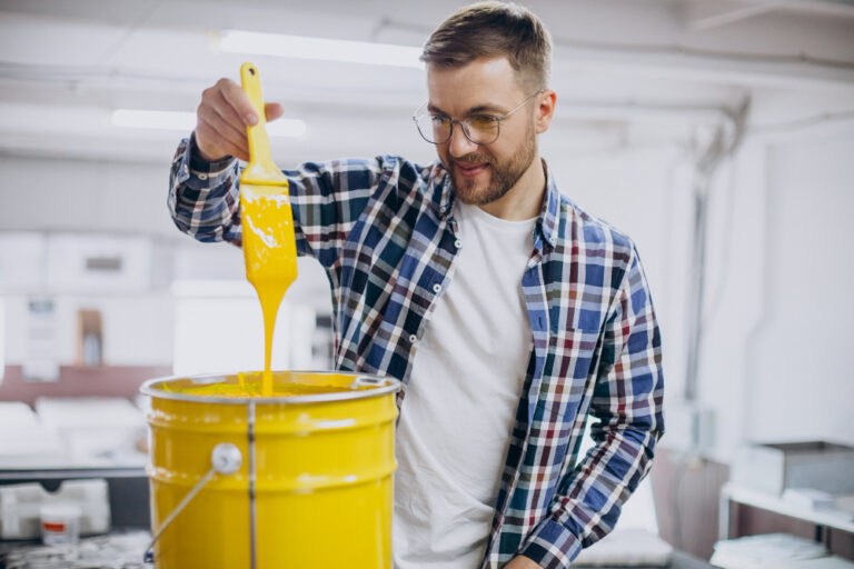 man-working-in-printing-house-with-paper-and-paints